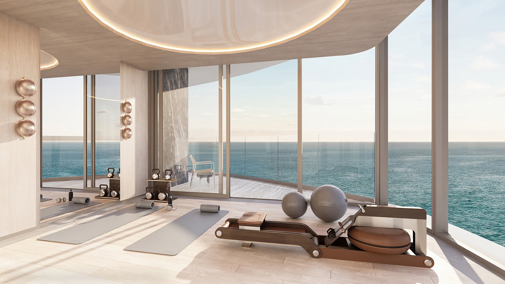 Upper Penthouse Rivage in Bal Harbour luxury and ultra luxury condos fitness area with yoga mats, weights, a Pilates reformer, mirrored wall, and ocean-facing glass.