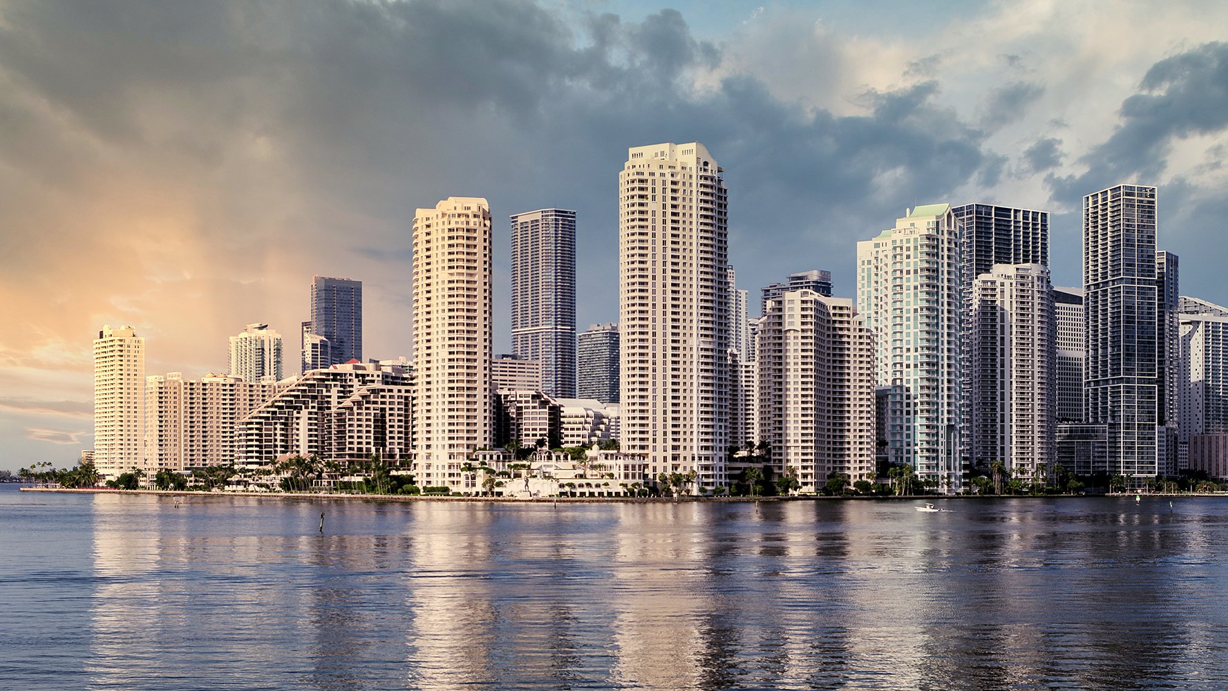 Miami skyline at twilight reflected on Biscayne Bay—vibrant market for luxury and ultra luxury condos; preconstruction and resale.