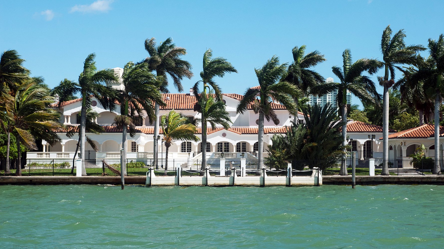 Venetian Islands seaside mansion with palms, exclusive Miami address near luxury and ultra luxury condos. Featuring island.