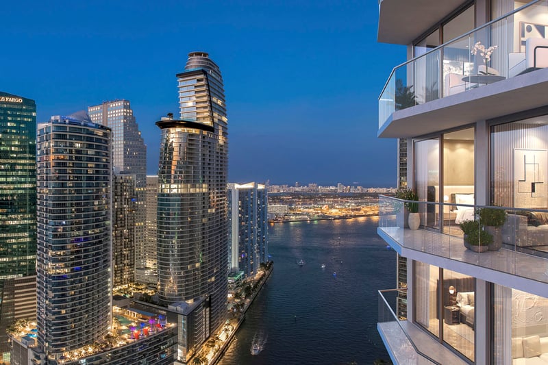 Viceroy Brickell The Residences in Brickell, Miami, luxury and ultra luxury preconstruction condos with a dusk balcony view over a waterfront channel, illuminated towers, and the downtown skyline.