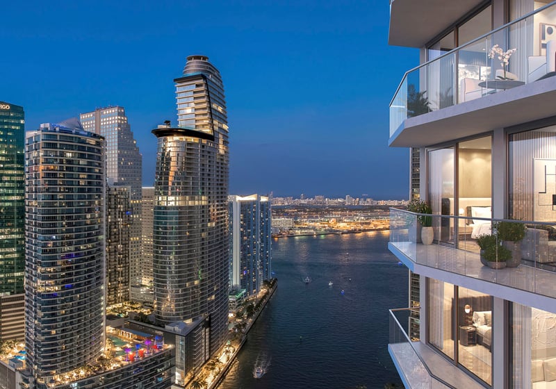 Viceroy Brickell The Residences in Brickell, Miami, luxury and ultra luxury preconstruction condos with a dusk balcony view over a waterfront channel, illuminated towers, and the downtown skyline.