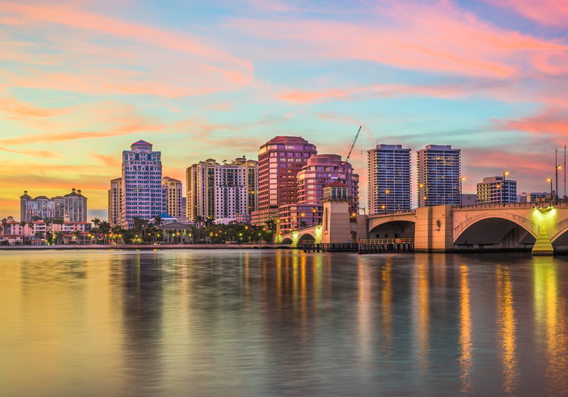 West Palm Beach sunset cityscape over the Intracoastal, pastel clouds and towers, destination for luxury and ultra luxury condos; preconstruction and resale. Featuring waterfront.