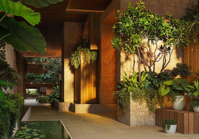 Lush lobby garden entry at Ziggurat Coconut Grove, Miami, Florida, featuring a lily-pond water feature, stone and wood finishes, and tropical plants, setting the tone for luxury living and ultra luxury preconstruction condos.