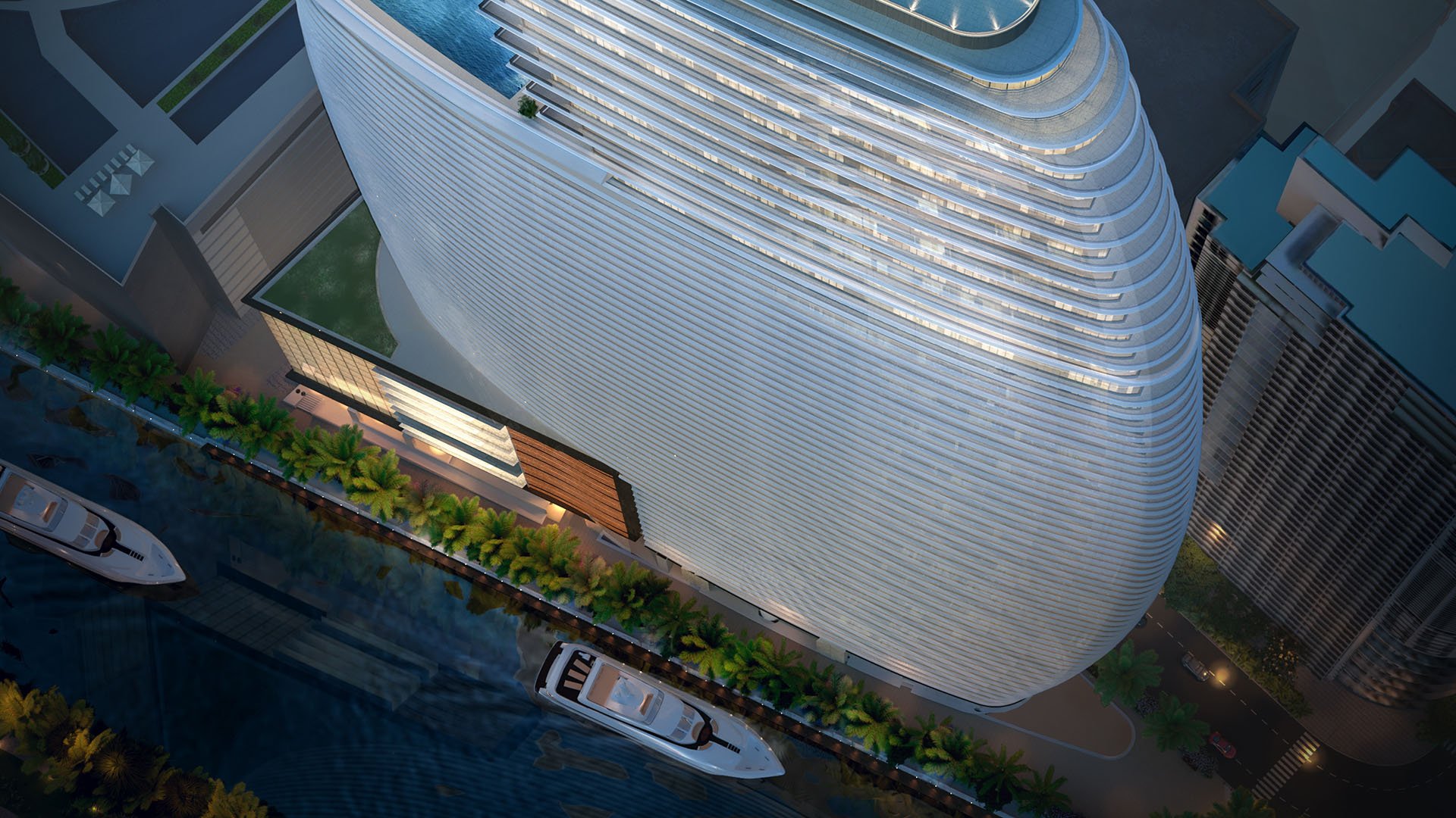 Aston Martin Residences in Downtown Miami luxury and ultra luxury condos top-down aerial of the curved waterfront tower with yachts, palm-lined frontage, and the rooftop pool deck.