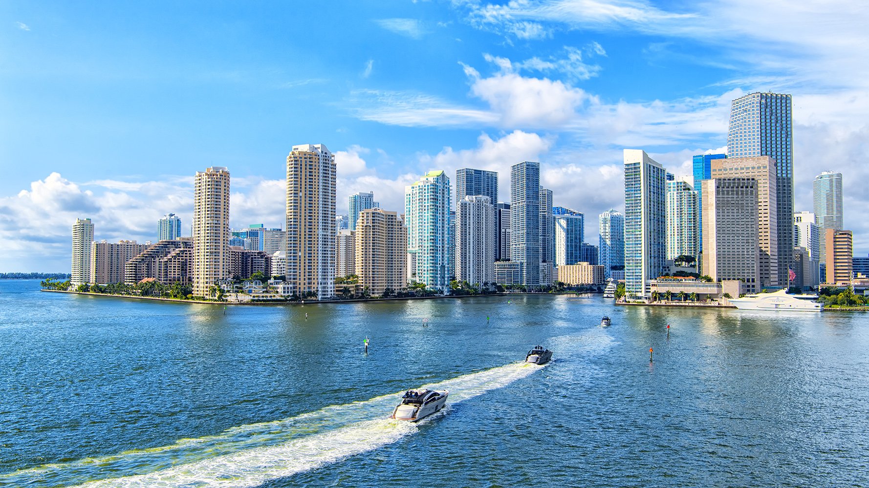 Brickell waterfront with boats on Biscayne Bay against the Miami skyline—sought‑after luxury and ultra luxury condos; active preconstruction and resale.