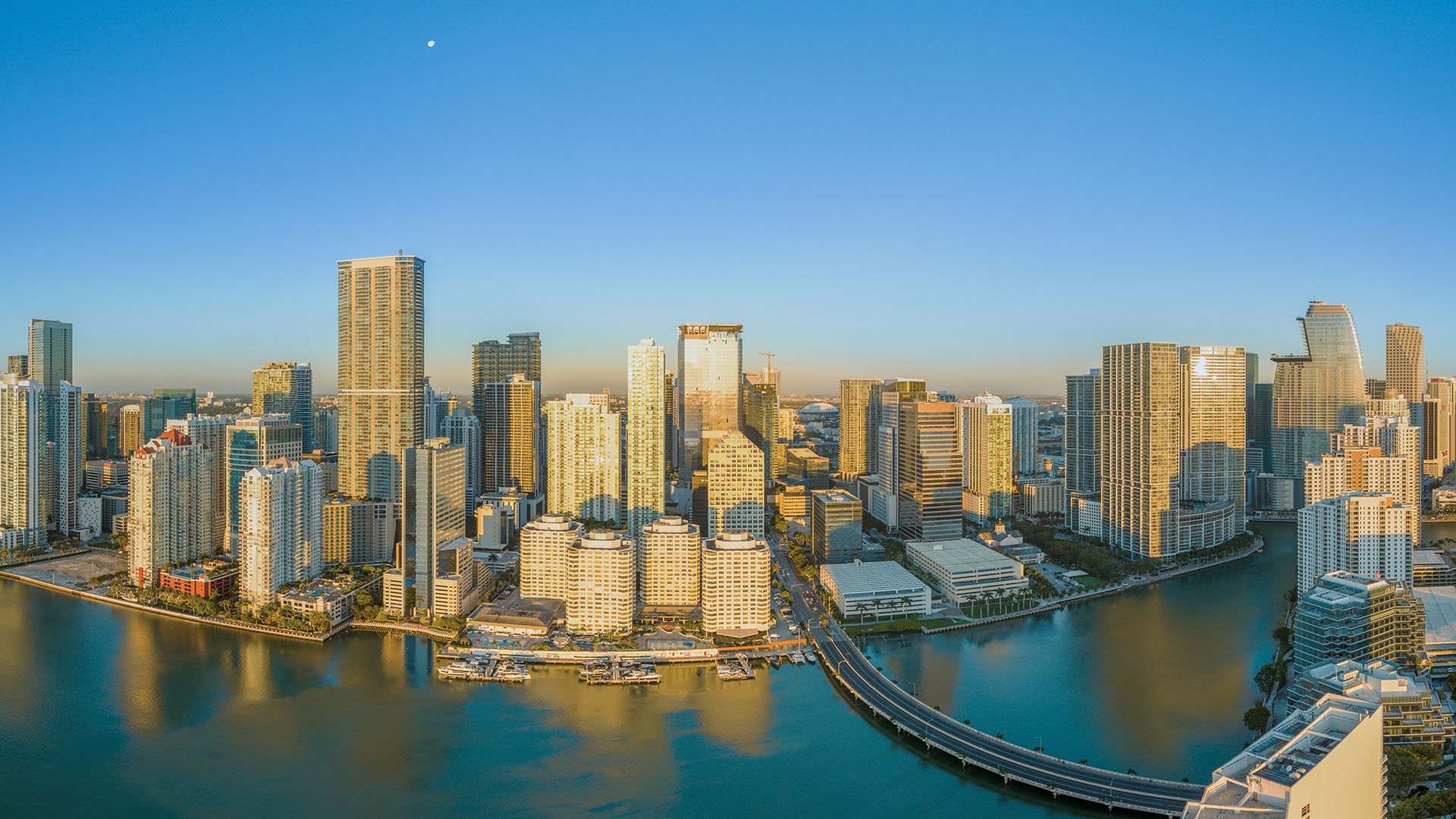Daytime aerial of Downtown Miami and Brickell waterfront towers with Brickell Key Bridge over Biscayne Bay, showcasing luxury and ultra luxury condos with preconstruction and resale inventory in Miami, Florida.