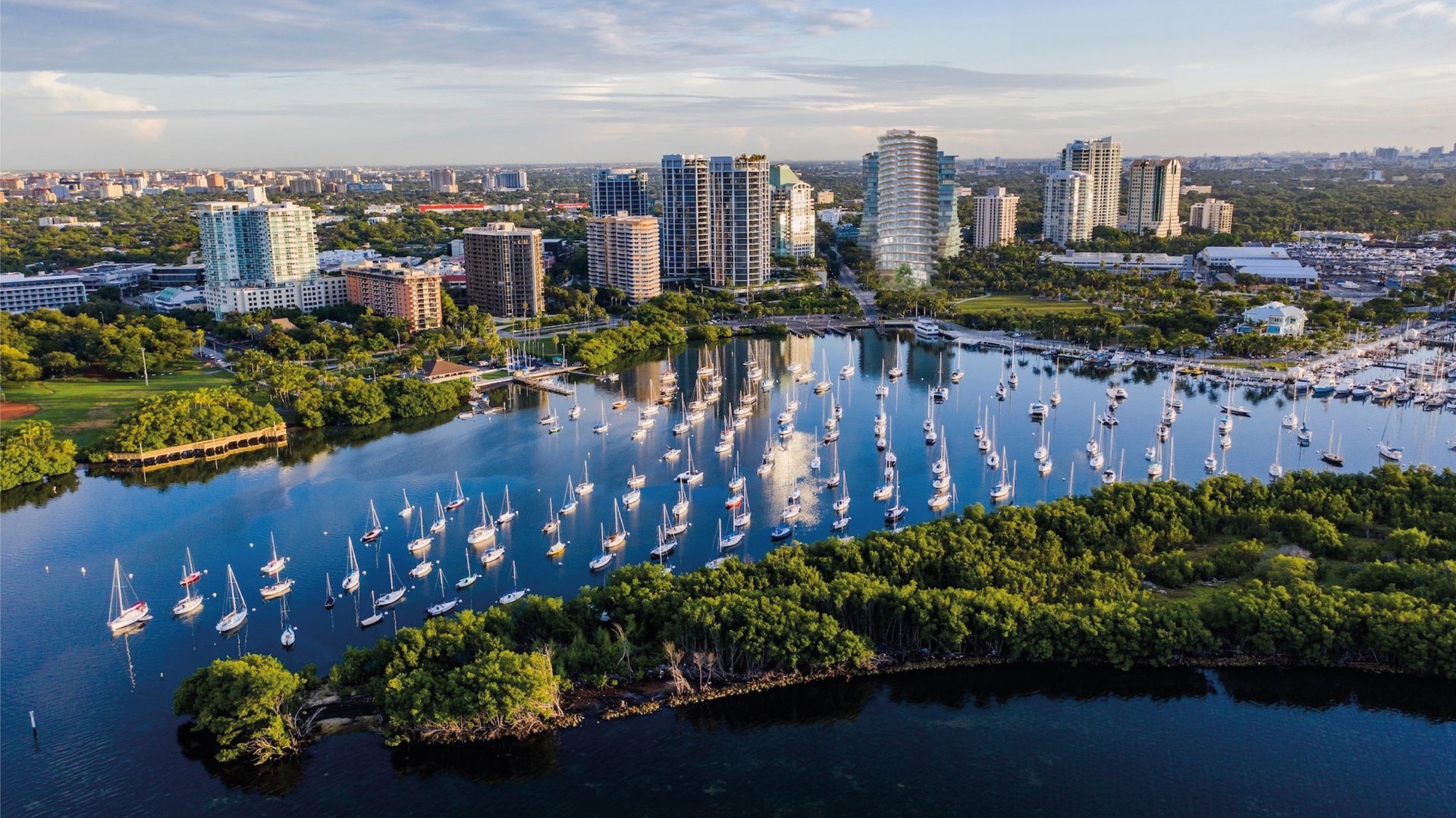 Four Seasons Coconut Grove, Miami waterfront marina at sunset with urban skyline—bayfront tower offering luxury and ultra luxury condos; prime preconstruction in Coconut Grove.