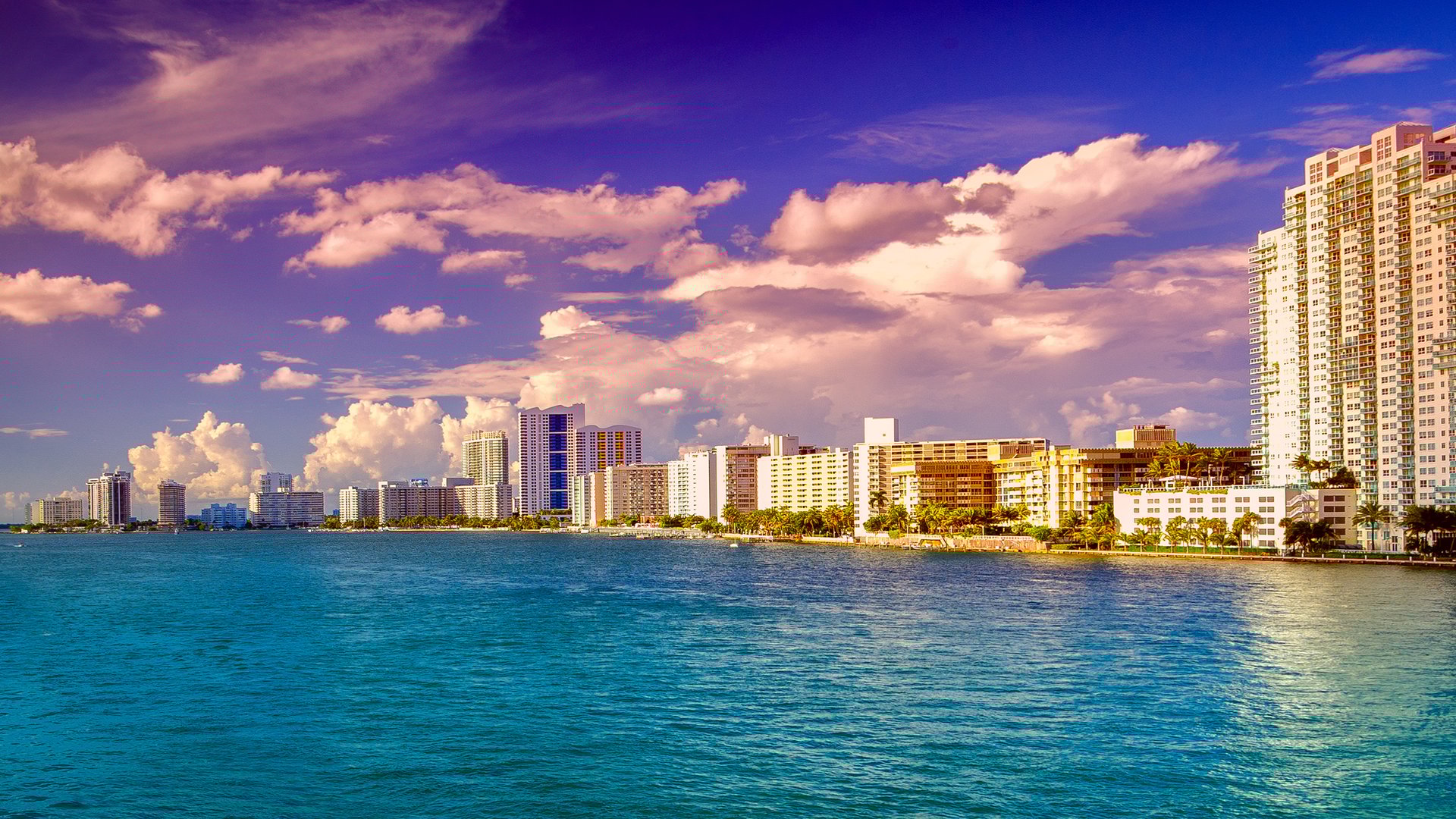 Hibiscus/Star/Palm Islands with Miami skyline at waterfront sunset, iconic bay views in an area known for luxury and ultra luxury condos; prime resale.