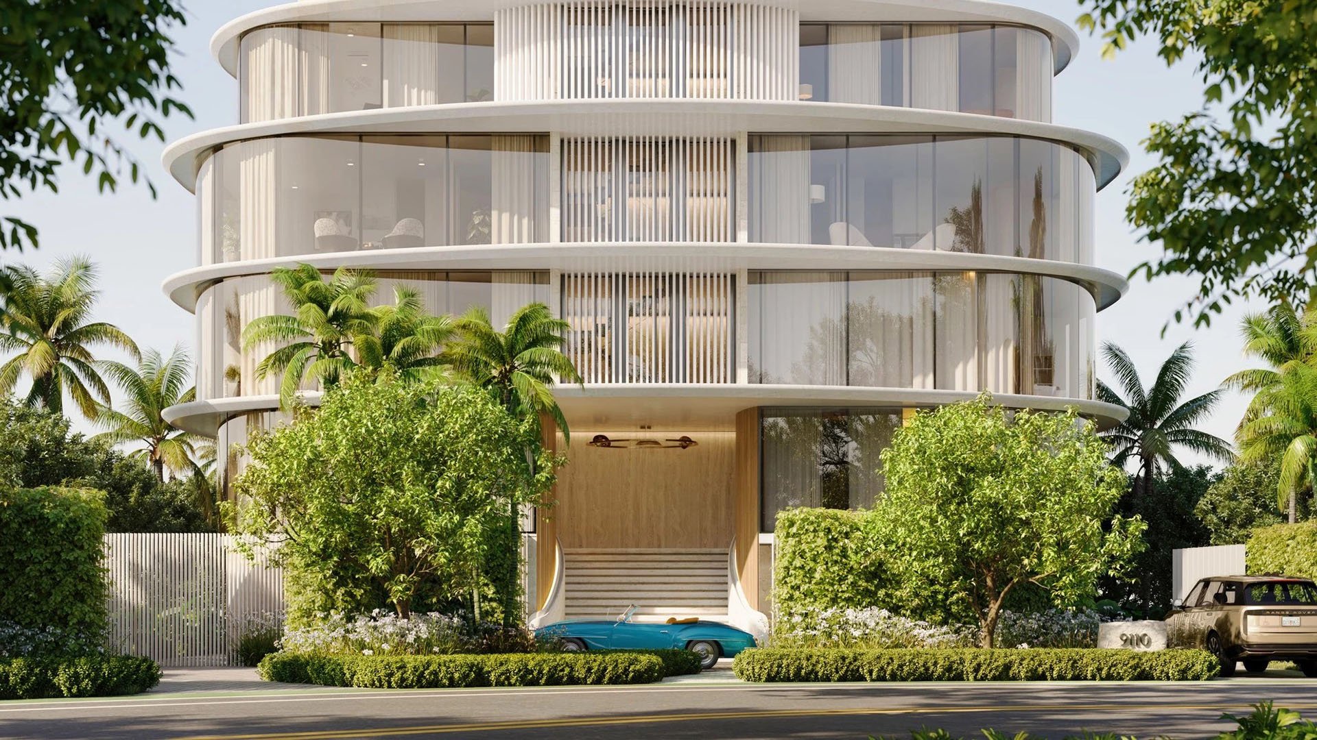 Indian Creek Residences and Yacht Club arrival entrance and porte cochere with lush landscaping and curved glass facade, Bay Harbor Islands, Miami area, Florida, luxury and ultra luxury preconstruction condos waterfront address.