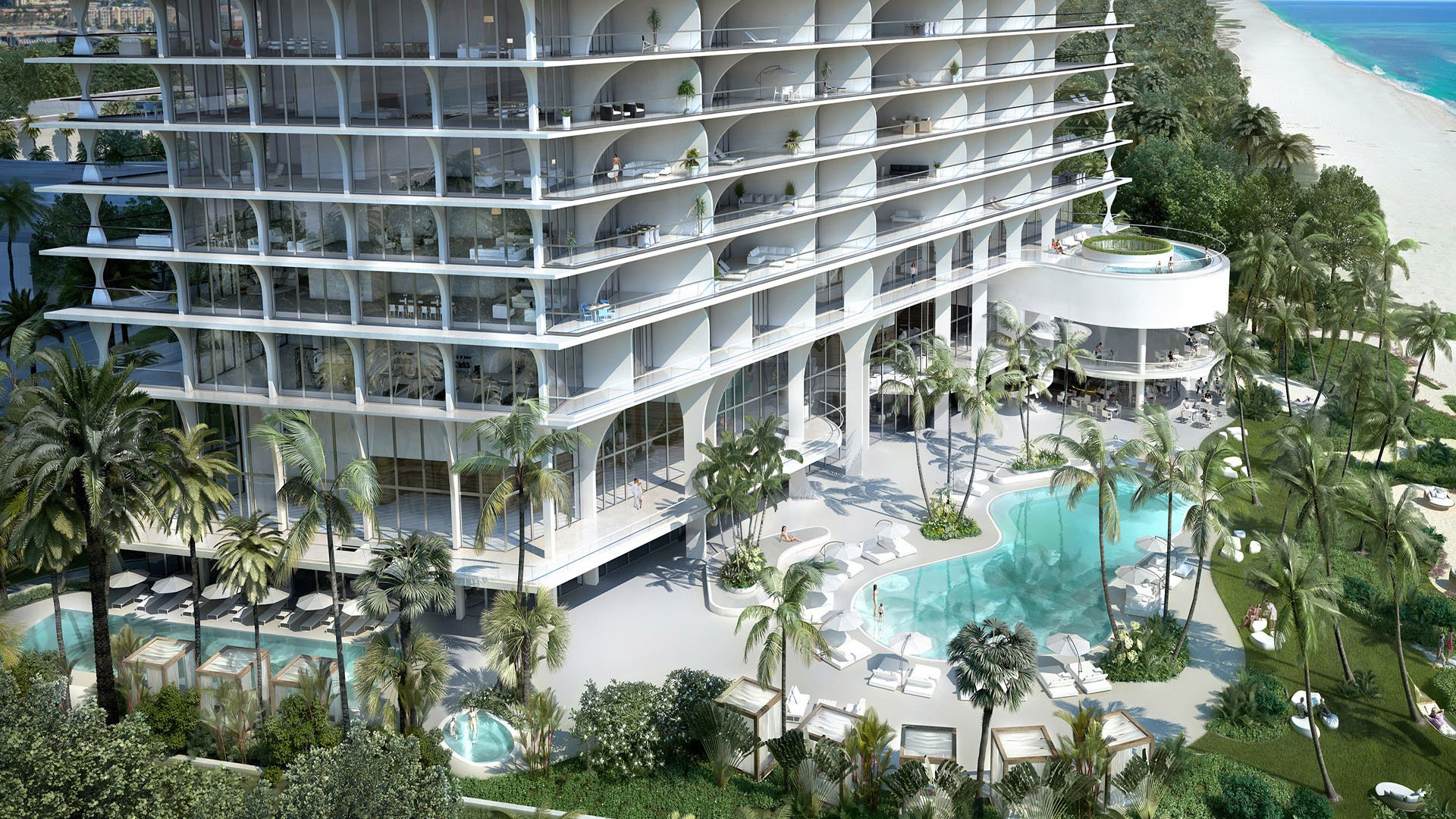 Jade Signature in Sunny Isles Beach luxury and ultra luxury condos aerial view of the pool courtyard with beachfront cabanas, curved balconies, lush palms and the sandy shore beside the tower.