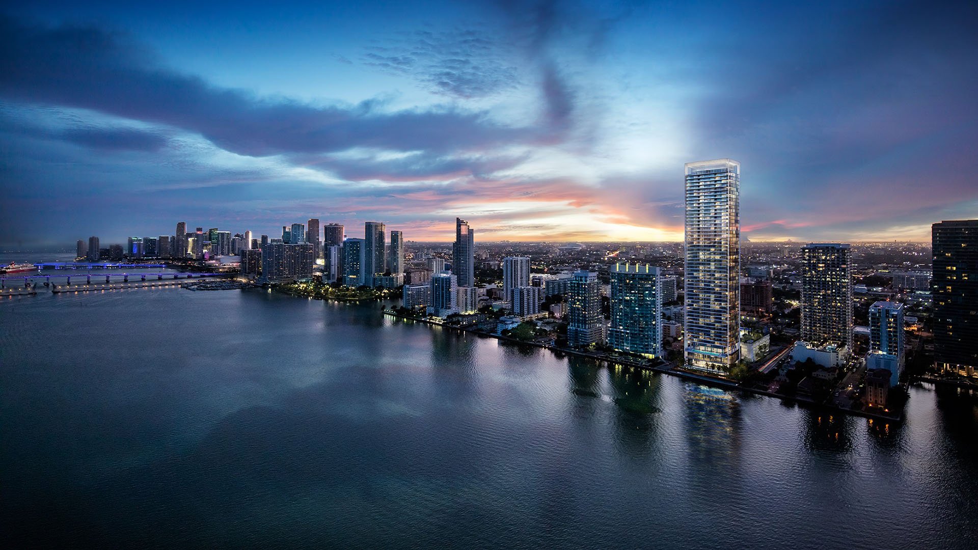 Missoni Baia Edgewater Miami aerial twilight over Biscayne Bay and Downtown Miami skyline, showcasing luxury and ultra luxury preconstruction condos waterfront tower.