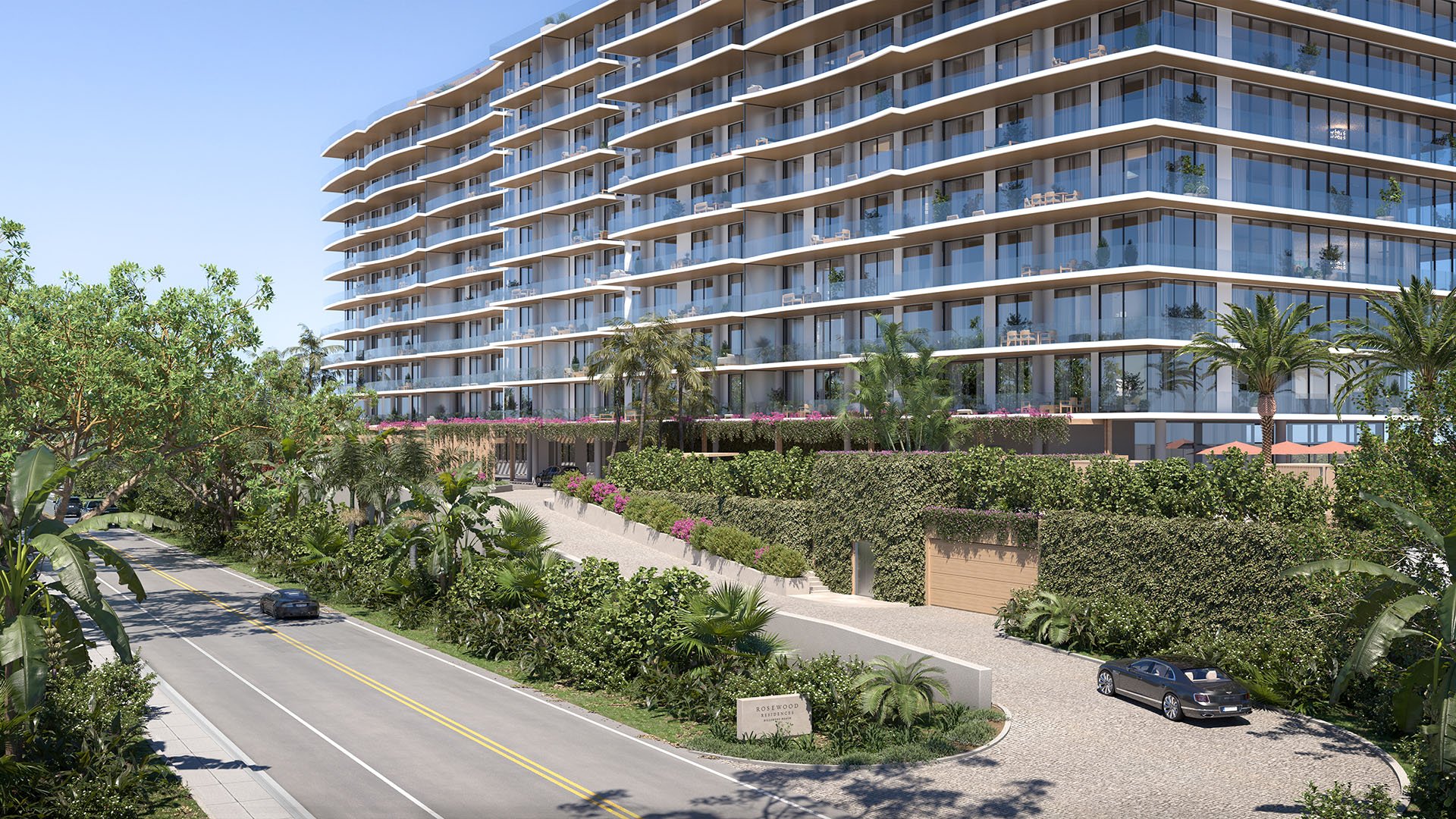 Rosewood Residences Hillsboro Beach, Florida street-view exterior with glass balconies, lush tropical landscaping and arrival driveway, showcasing luxury and ultra luxury preconstruction condos.