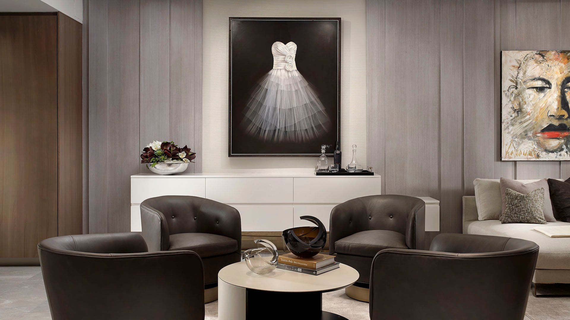 Turnberry Ocean Club in Sunny Isles Beach luxury and ultra luxury condos showcase a gallery-style living room with dark lounge chairs, art walls, and a calm ocean backdrop.